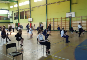 Uczniowie klas ósmych w hali gimnastycznej na uroczystości ukończenia szkoły
